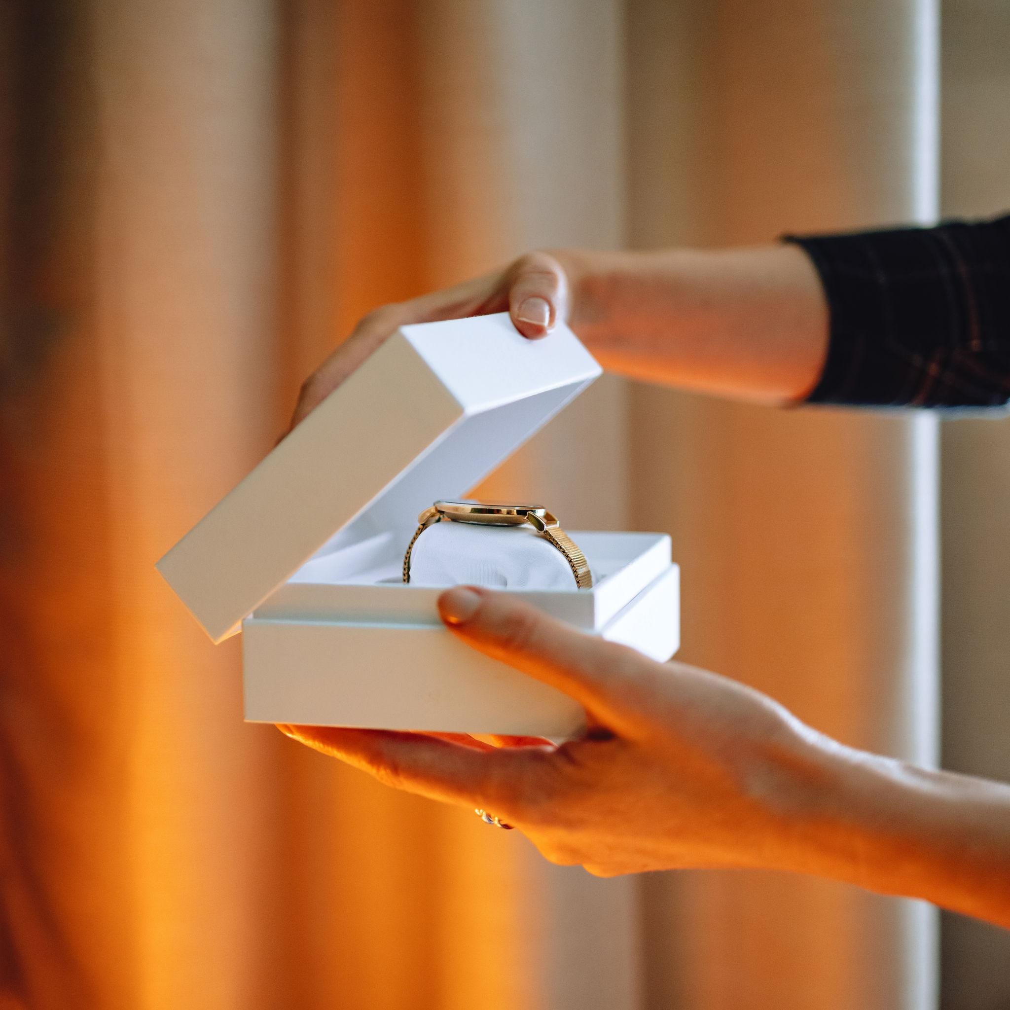 Watch in a branded gift box being handed to a customer